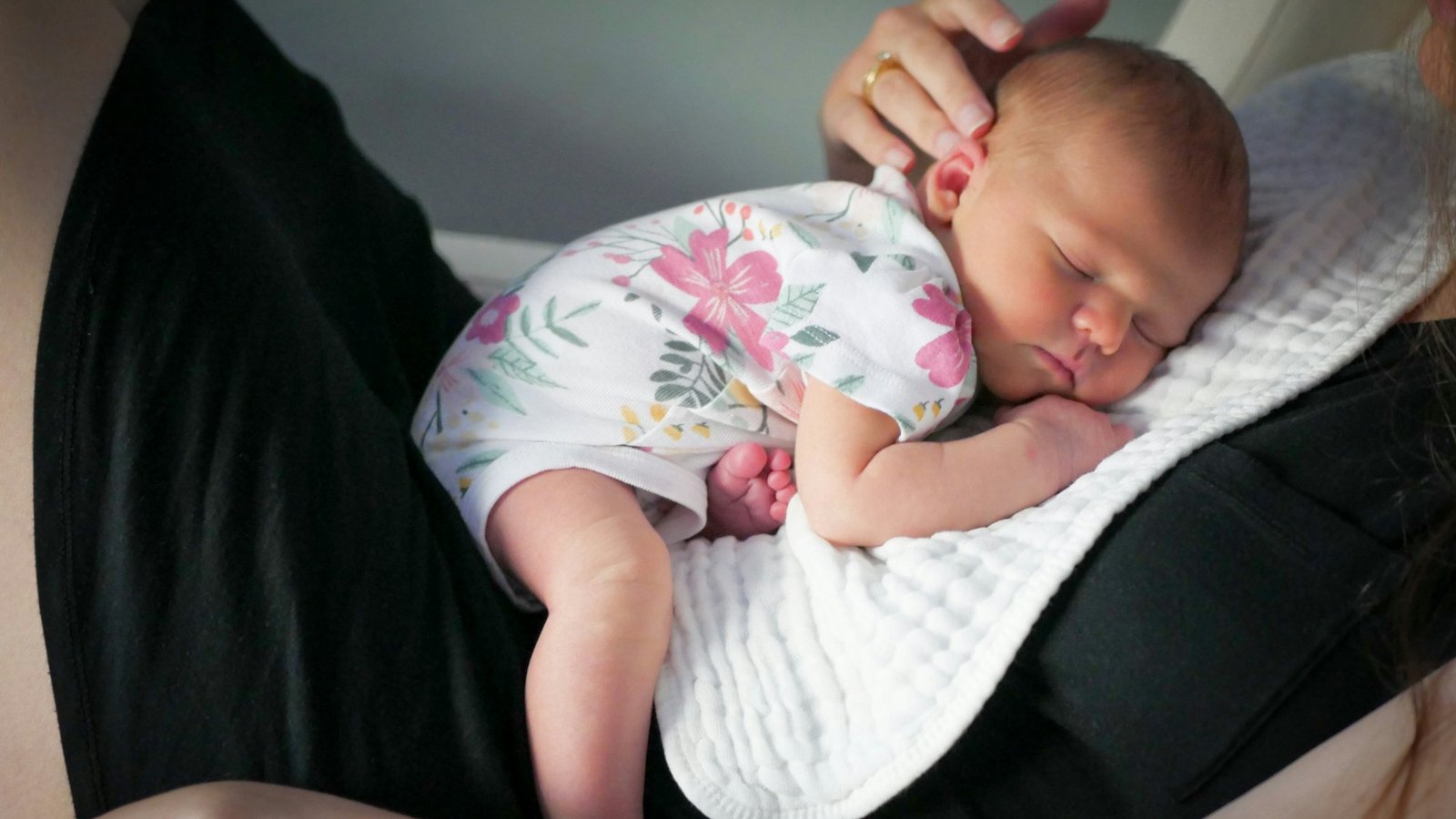 Recién nacido dormido sobre el pecho de su madre, luz suave